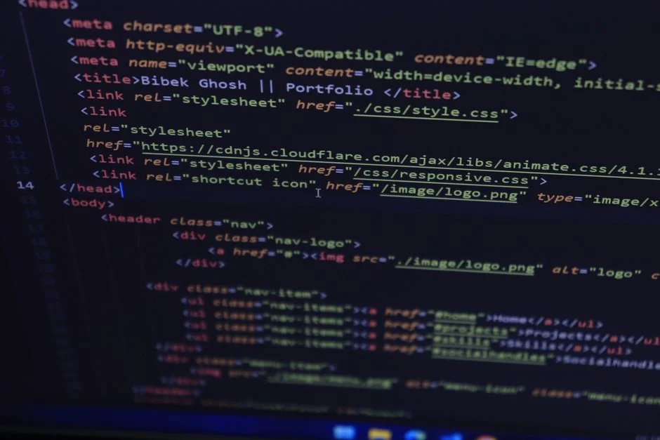 Close-up of hands typing on a laptop next to a cup of coffee on a wooden desk.