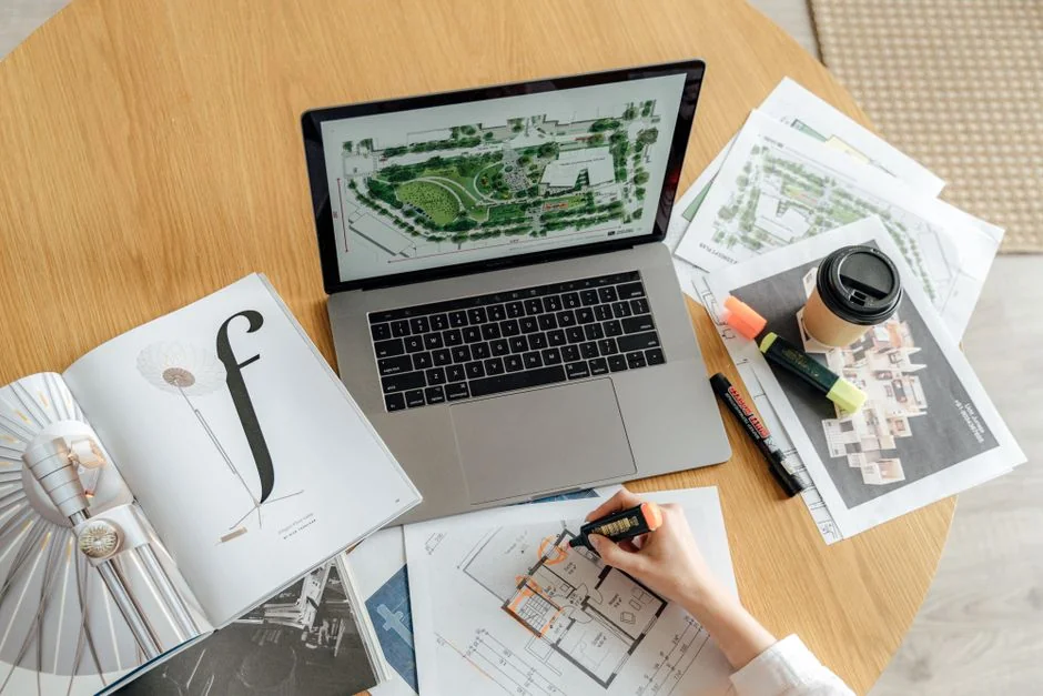 Business professional using a tablet and laptop with a hot drink, focusing on digital content review.